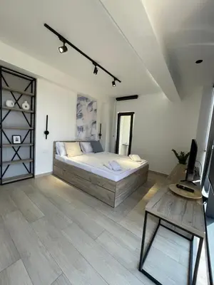 a bedroom with a large bed and a table at Dora Family Apartments Budva in Budva