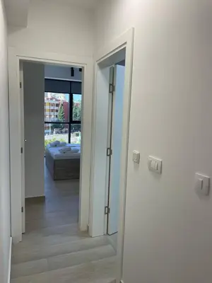 a hallway with a mirror and a bed in a room at Dora Family Apartments Budva in Budva