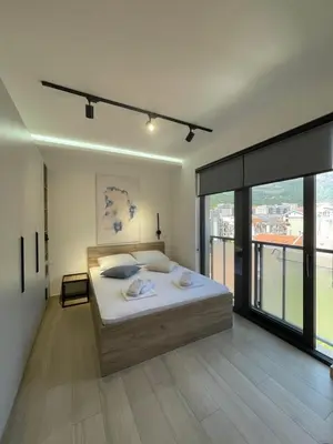 a bedroom with a bed and a large window at Dora Family Apartments Budva in Budva