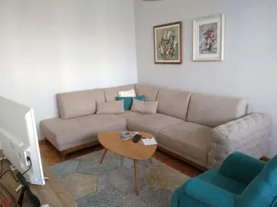 a living room with a couch and a table at Main bus station apartment in Podgorica