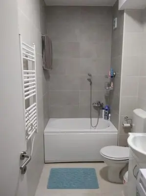 a white bathroom with a tub and a toilet at Main bus station apartment in Podgorica