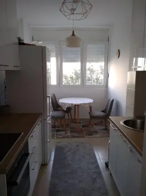 a kitchen with a table and chairs in a kitchen at Main bus station apartment in Podgorica