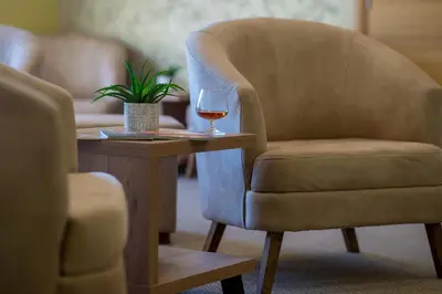 a chair and a glass of wine on a table at Hotel WGrand in Petrovac na Moru