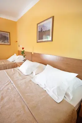 a bedroom with two beds with white pillows at Hotel WGrand in Petrovac na Moru