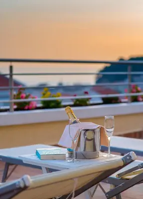 a table with a tea kettle and glasses on a boat at Hotel WGrand in Petrovac na Moru