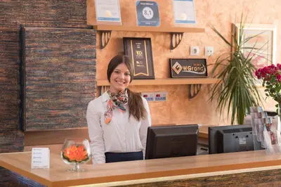 a woman sitting at a counter in a coffee shop at Hotel WGrand in Petrovac na Moru