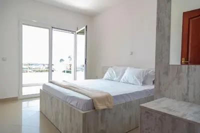 a bedroom with a large bed and a large window at Villa Erik in Ulcinj