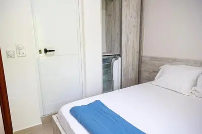 a bedroom with a white bed with a blue towel on it at Villa Erik in Ulcinj