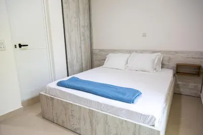 a white bed with a blue pillow on it at Villa Erik in Ulcinj