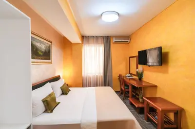 a hotel room with a bed and a desk at Hotel Kerber in Podgorica