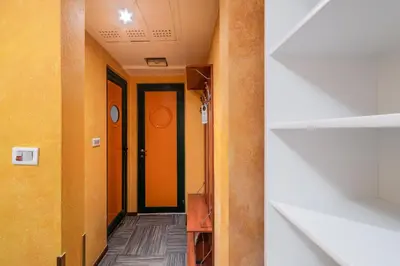 a hallway with yellow walls and orange doors at Hotel Kerber in Podgorica