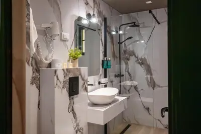 a bathroom with a sink and a mirror at Hotel Kerber in Podgorica