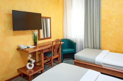 a hotel room with a bedroom with a desk and a bed at Hotel Kerber in Podgorica