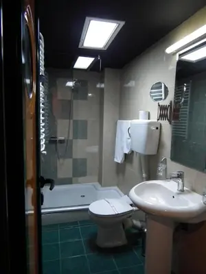 a bathroom with a sink and a toilet and a tub at Hotel Kerber in Podgorica