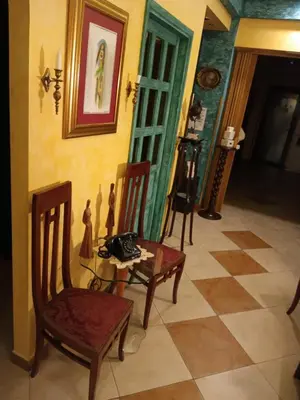 a room with two chairs and a table and a room with a wall at Hotel Kerber in Podgorica