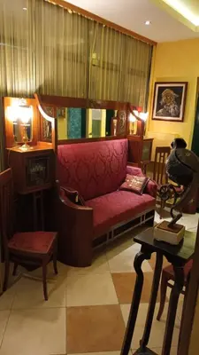 a living room with a red couch and a table at Hotel Kerber in Podgorica