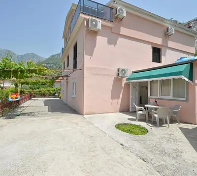 a pink house with a table and chairs outside at DREAM S&L in Kotor