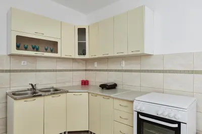 a kitchen with white cabinets and a sink at DREAM S&L in Kotor