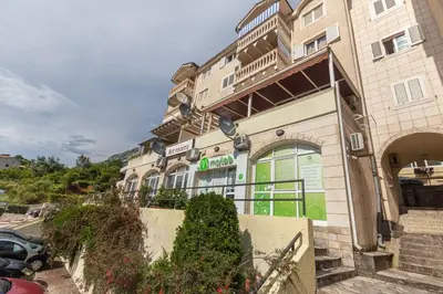 a building with a green door on a street at Sailor's Knot Apartment - Central and Amazing Sea View in Kotor