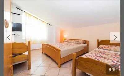 a bedroom with two beds and a chair in it at Maki Apartments - Plavi Horizonti Beach in Tivat