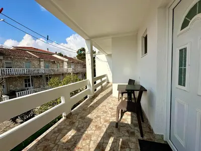 a balcony with a table and a white door at Maki Apartments - Plavi Horizonti Beach in Tivat