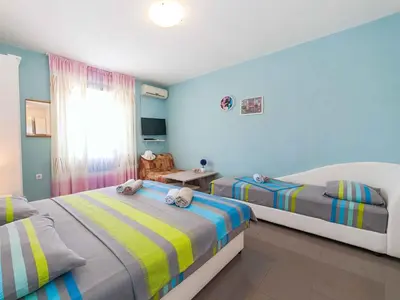 a bedroom with two beds and a table and a window at Maki Apartments - Plavi Horizonti Beach in Tivat