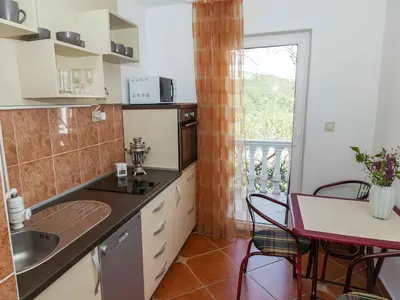 a kitchen with a sink and a table and a window at Maki Apartments - Plavi Horizonti Beach in Tivat