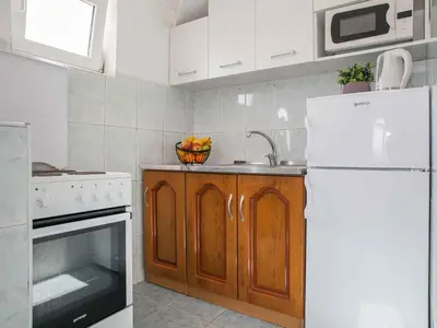 a kitchen with a white refrigerator and a sink at Maki Apartments - Plavi Horizonti Beach in Tivat