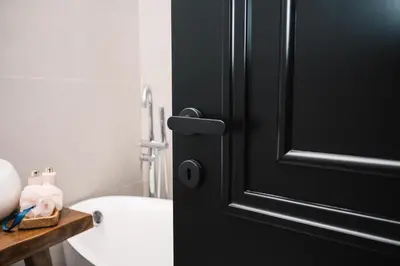 a black door in a bathroom with a toilet and a sink at KAAB Boutique Hotel in Ulcinj