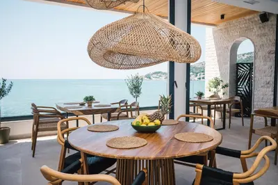 a restaurant with tables and chairs with a view of the ocean at KAAB Boutique Hotel in Ulcinj