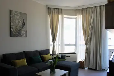 a living room with a blue couch and a window at Diva Petra Apartments in Budva