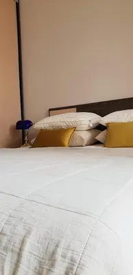 a bed with white sheets and pillows on it at Diva Petra Apartments in Budva
