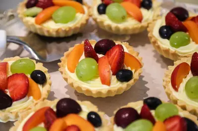 a bunch of small pies with fruit on them at Monte Casa SPA & Wellness in Petrovac na Moru