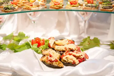 a plate of food on a table with glasses of wine at Monte Casa SPA & Wellness in Petrovac na Moru