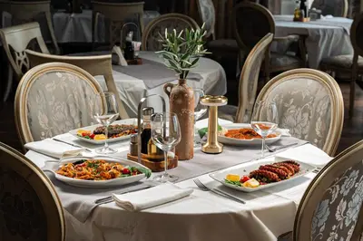 a table with plates of food on a table at Hotel Adrović in Sveti Stefan
