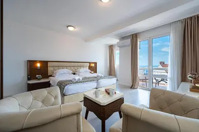 a hotel room with a bed and a balcony at Hotel Adrović in Sveti Stefan