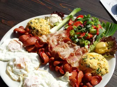 a plate of food with eggs and vegetables on a table at Hotel Keto in Podgorica
