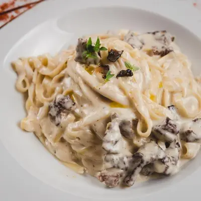 a plate of pasta with mushrooms on a white plate at Hotel Keto in Podgorica