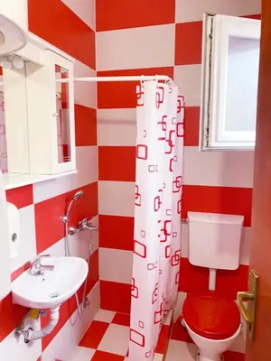 a bathroom with a red and white striped wall at Apartmani LANA Podgorica in Podgorica