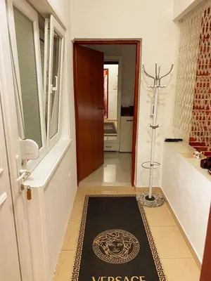 a hallway with a door with a compass rug on the floor at Apartmani LANA Podgorica in Podgorica