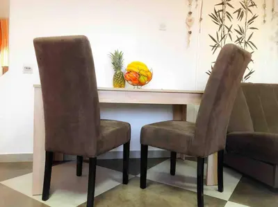 a table with two chairs and a bowl of fruit at Apartmani LANA Podgorica in Podgorica