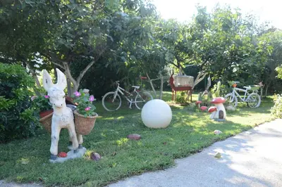 a garden with a statue of a rabbit in the grass at Apartmani LANA Podgorica in Podgorica