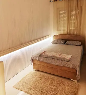 a bedroom with a bed and a rug in it at Apartmani LANA Podgorica in Podgorica