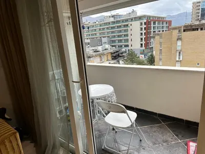 a white chair sitting on a balcony with a window at Lux Apartment Budva in Budva