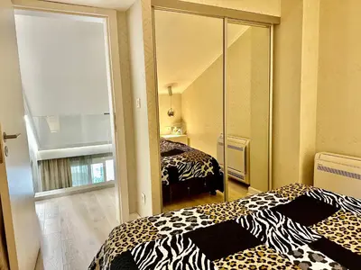 a bedroom with two beds and a mirror at Lux Apartment Budva in Budva