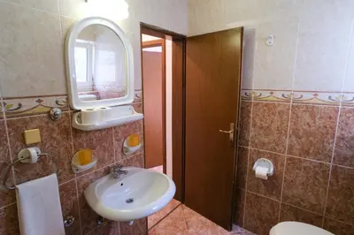 a bathroom with a sink and a mirror and a toilet at Villa Maxima Budva in Budva