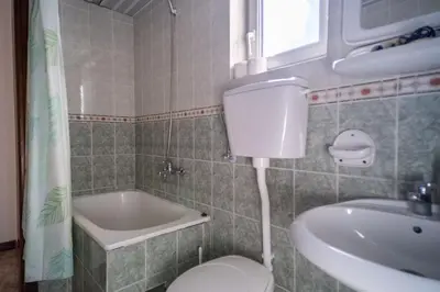 a bathroom with a toilet and a sink and a tub at Villa Maxima Budva in Budva