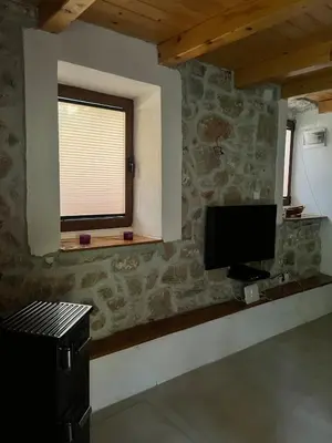 a living room with a tv and a window at Lake Point Dodoši in Cetinje