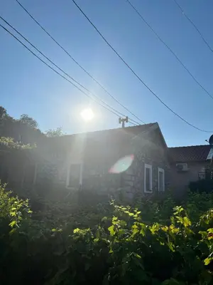 a house with the sun shining on the roof at Lake Point Dodoši in Cetinje
