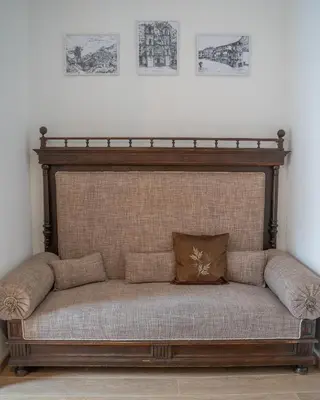 a couch in a room with drawings on the wall at Main Square View in Kotor